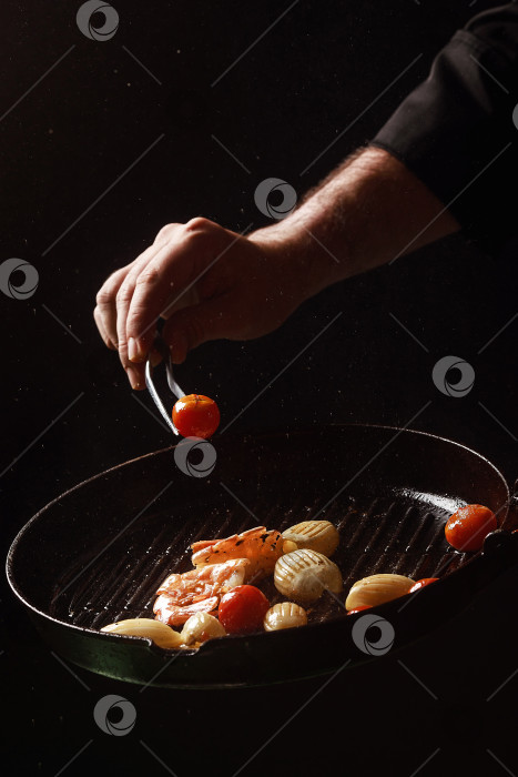 Скачать Шеф-повар готовит морепродукты, креветки на сковороде с овощами. фотосток Ozero