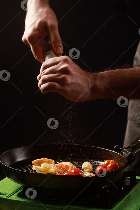 Скачать Шеф-повар готовит морепродукты, креветки на сковороде с овощами. фотосток Ozero