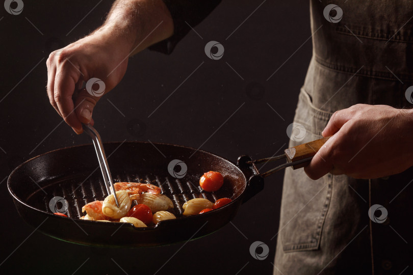Скачать Шеф-повар готовит морепродукты, креветки на сковороде с овощами. фотосток Ozero