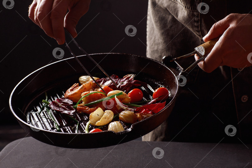 Скачать Шеф-повар готовит морепродукты, креветки на сковороде с овощами. фотосток Ozero