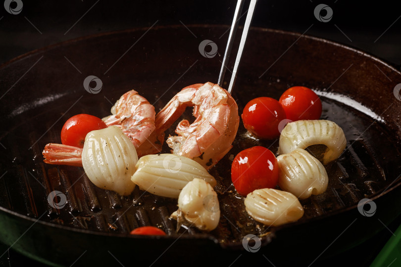 Скачать Шеф-повар готовит морепродукты, креветки на сковороде с овощами. фотосток Ozero