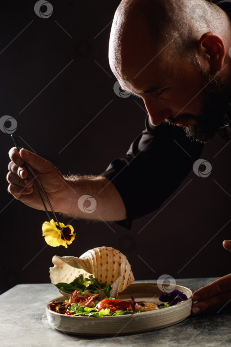 Скачать Шеф-повар готовит салат из морепродуктов и овощей. фотосток Ozero