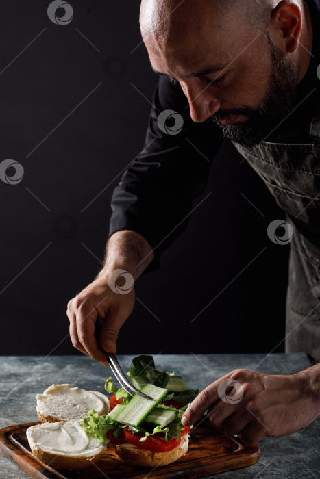 Скачать Шеф-повар готовит бургеры в ресторане. фотосток Ozero