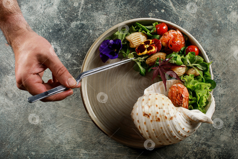 Скачать Шеф-повар готовит салат из морепродуктов и овощей. фотосток Ozero