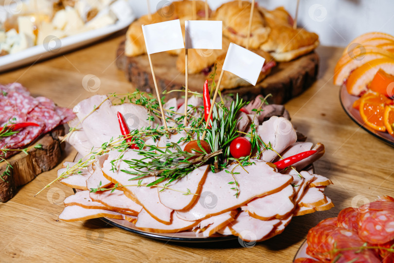 Скачать Нарезанное мясное ассорти украсьте зеленью. фотосток Ozero