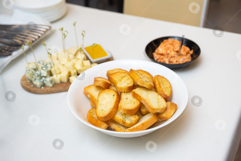 Скачать Поджаренные ломтики багета с кубиками сыра и начинкой. фотосток Ozero