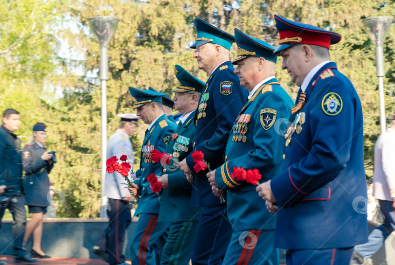 Скачать Высокопоставленные военные офицеры стоят с цветами для возложения к памятнику в честь 9 мая фотосток Ozero