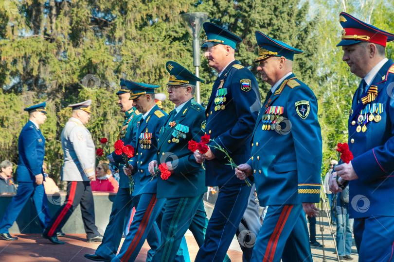 Скачать Высокопоставленные военные идут с цветами, чтобы возложить их к памятнику в честь 9 мая. фотосток Ozero