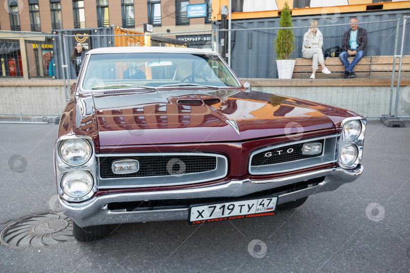 Скачать Бордовый Pontiac GTO 1966 года выпуска на выставке ретроспектива оригинальной коллекции, вид спорта фотосток Ozero
