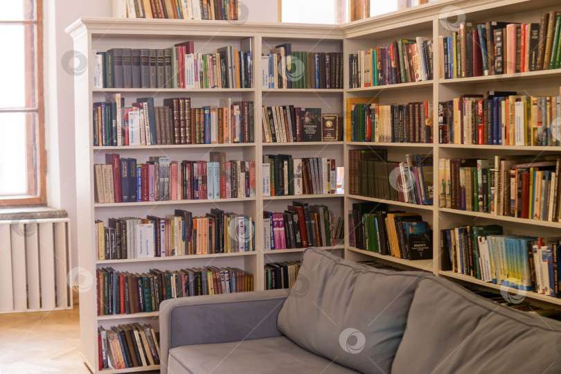 Скачать Книжная полка с большим количеством книг в публичной библиотеке, фотография со стока фотосток Ozero