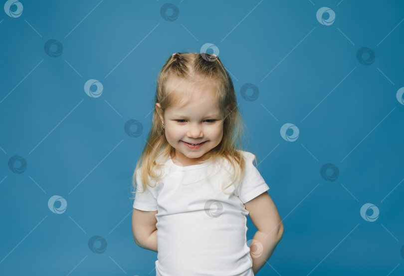Скачать Маленькая девочка 2-3 лет весело смеется. . портрет маленького ребенка на синем фоне. фотосток Ozero