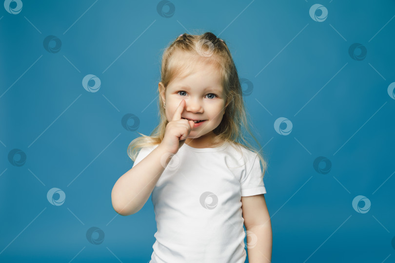 Скачать Маленькая девочка 2-3 лет, держащая указательный палец вверх, с хорошей идеей, выделенной на синем фоне, детский студийный портрет. День матери, любовь, семья, люди, стиль жизни, концепция фотосток Ozero