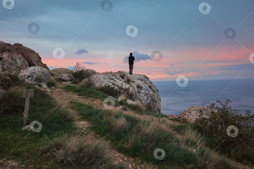 Скачать Путешественник на вершине горы на закате. фотосток Ozero