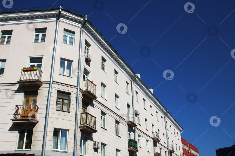 Скачать Высокое белое здание, за которым прекрасно просматривается голубое небо фотосток Ozero