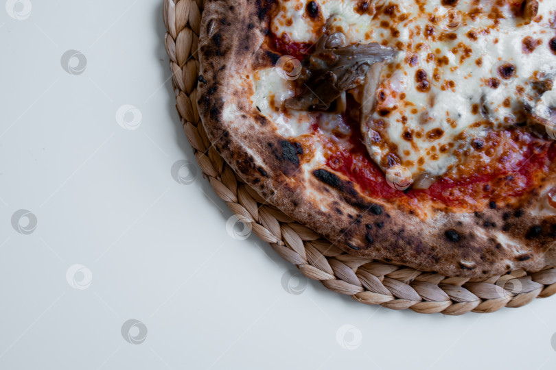 Скачать Вкуснейшая сырная пицца с грибами на плетеной салфетке фотосток Ozero