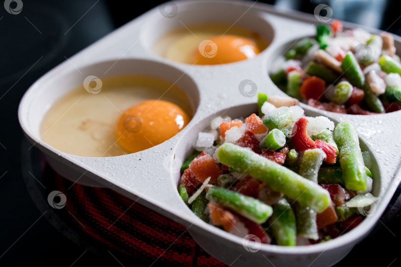 Скачать Замороженные овощи и сырые яйца в лотке, готовые к приготовлению фотосток Ozero