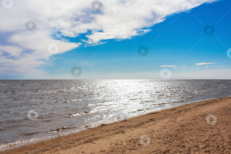 Скачать Песчаный пляж в солнечный день, синяя вода, свет Солнца отражается в воде, голубое небо и белые облака фотосток Ozero