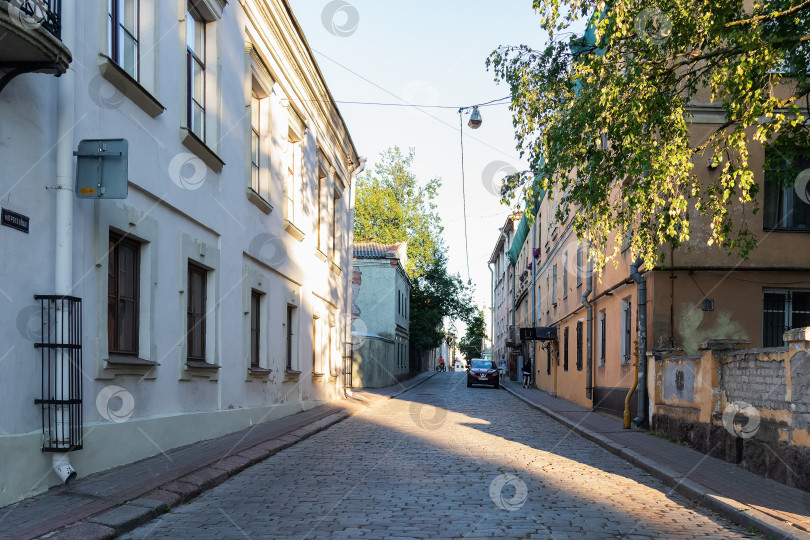 Скачать Городская улица с булыжной мостовой и старыми домами, летний день фотосток Ozero