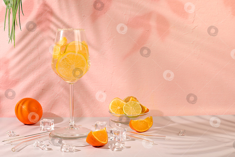 Скачать Праздничный алкогольный коктейль Aperol spritz с апельсином, лимоном и кубиками льда, концепция летнего бара, баннер с алкогольными напитками и тропическими фруктами. Меню ресторана, визитная карточка кафе. фотосток Ozero