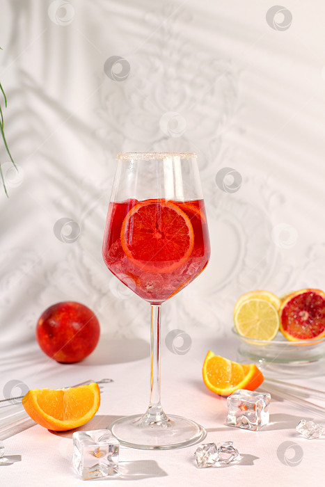 Скачать Королевский коктейль aperol sprits с кровавым апельсином, кубиками льда, ромом и текилой. Концепция летней вечеринки и отдыха в ресторане. Баннер с бокалами алкогольных напитков и тропическими фруктами. Меню для бара или кафе. фотосток Ozero