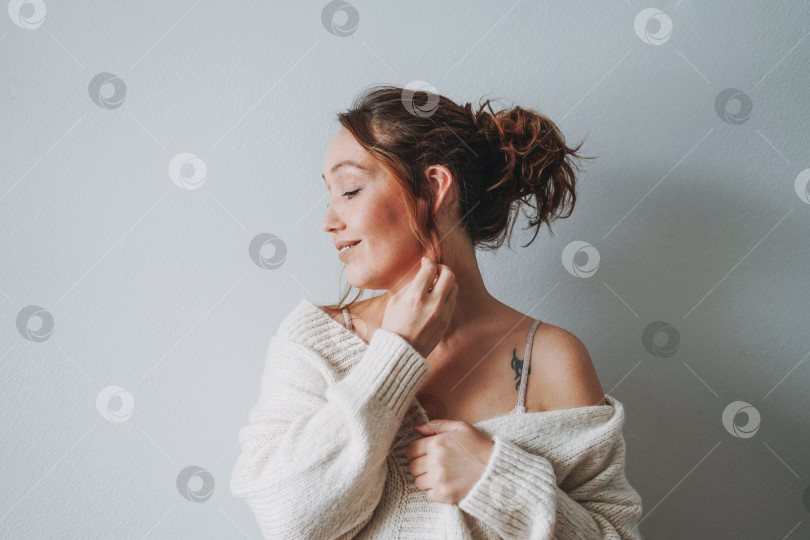 Скачать Привлекательная чувственная улыбающаяся брюнетка среднего возраста в домашней уютной атмосфере холодного времени года фотосток Ozero