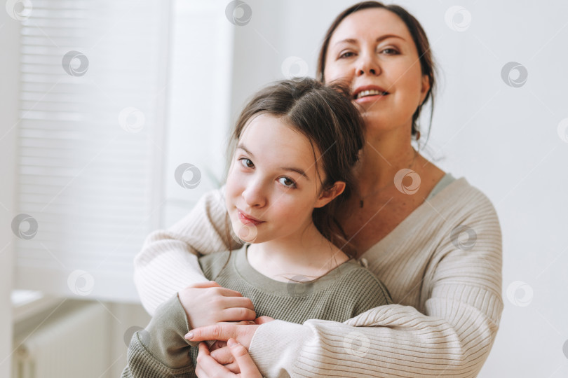 Скачать Привлекательная мать-женщина средних лет и дочь-подросток вместе в светлом интерьере фотосток Ozero
