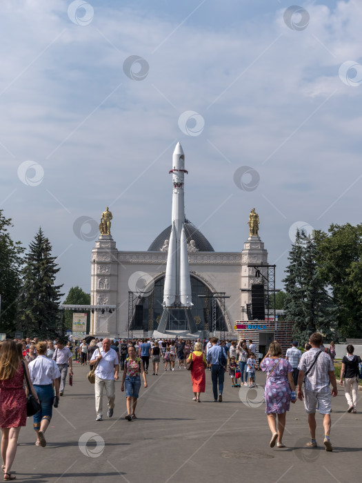 Скачать МОСКВА, РОССИЯ - 23 апреля 2024 года: Ракета-носитель "Восток" в павильоне "Космос" на ВДНХ. Гуляющие москвичи и туристы фотосток Ozero