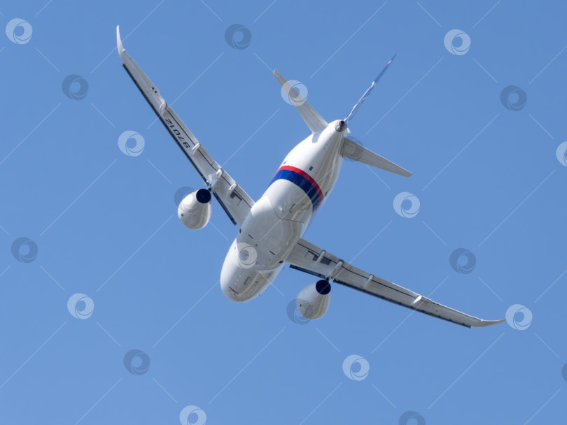 Скачать Москва, Россия, аэродром Жуковский, 25 июля 2021 года: Коммерческий пассажирский самолет Sukhoi Superjet 100 совершает демонстрационный полет в рамках международного аэрокосмического салона МАКС-2021. фотосток Ozero