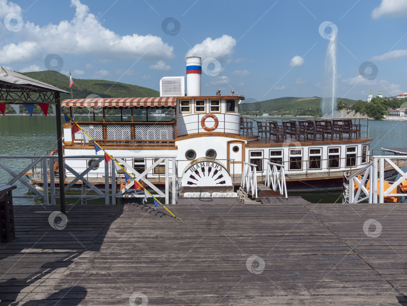 Скачать Абрау-Дюрсо, Россия, 28 августа 2024 года: Ретро-пароход "Шампань" пришвартован к причалу на набережной озера Абрау-Дюрсо фотосток Ozero