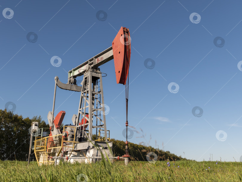 Скачать Действующая нефтяная и газовая скважина на нефтяном месторождении, очерченная профилем на фоне голубого неба фотосток Ozero