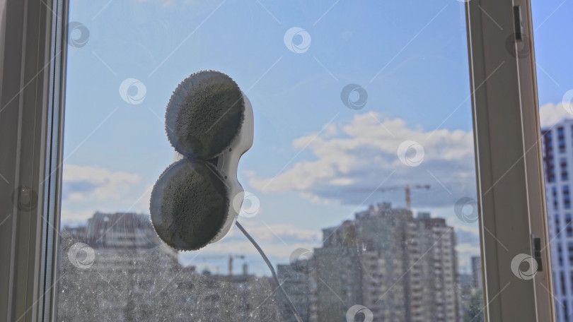 Скачать Робот-мойщик окон моет стекло круглыми тряпками, роботизированный сервис, современные технологии фотосток Ozero