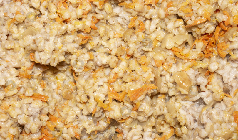 Скачать Перловая крупа с луком и морковью.Перловая крупа домашнего приготовления, вид сверху.На заднем плане - отварная перловая крупа. фотосток Ozero