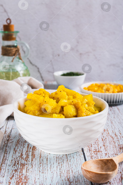 Скачать Вегетарианское карри с картофелем и цветной капустой в миске на столе, вид сверху фотосток Ozero
