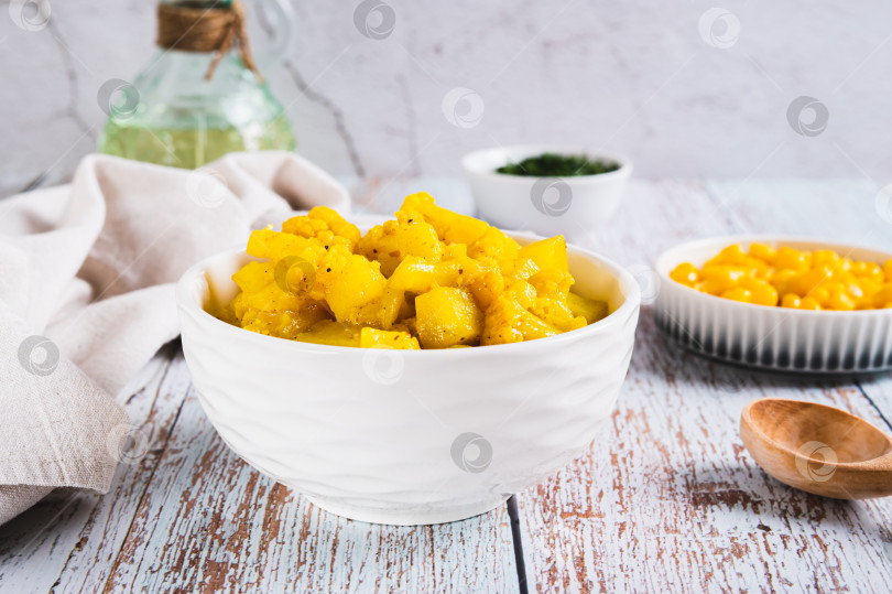 Скачать Вегетарианское карри с картофелем и цветной капустой в миске на столе фотосток Ozero