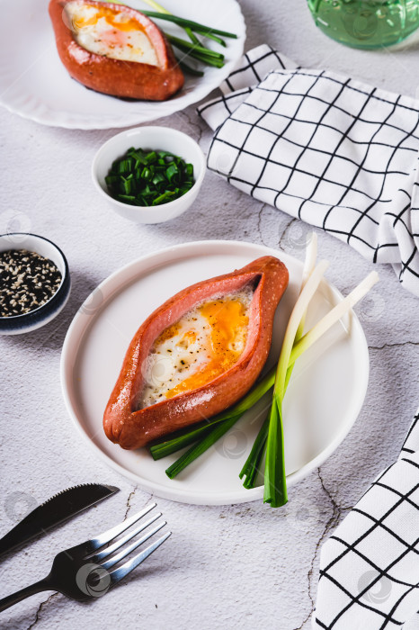 Скачать Колбаса, фаршированная жареным яйцом и чесноком, на тарелке на столе, вид сверху фотосток Ozero