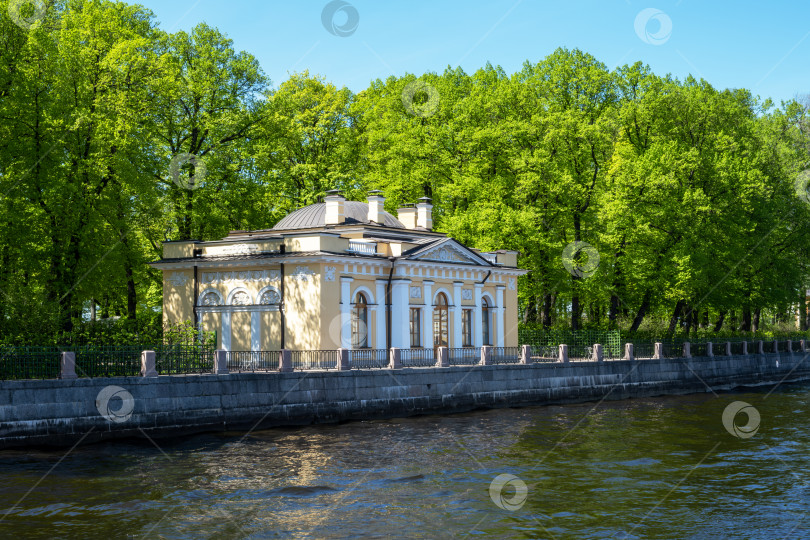 Скачать Санкт-Петербург, Россия - 21.05.2024. Элегантное историческое здание на берегу реки в окружении зелени Летнего сада фотосток Ozero
