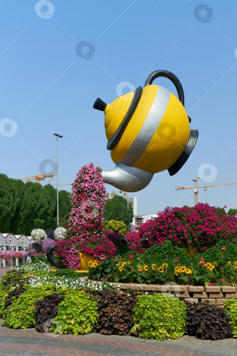 Скачать Желтый чайник и чашка с яркими цветами в Miracle Garden в Дубае. фотосток Ozero
