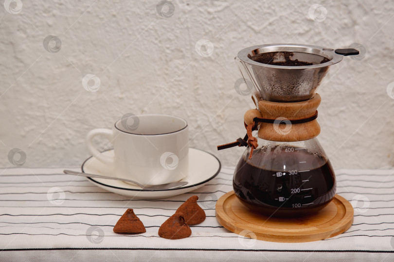 Скачать Стеклянная кофеварка chemex с вкусным капельным кофе в зернах на белом столе. Место для текста фотосток Ozero