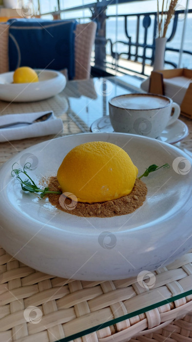 Скачать Пироженое в форме лимона и кофе в кружке. фотосток Ozero