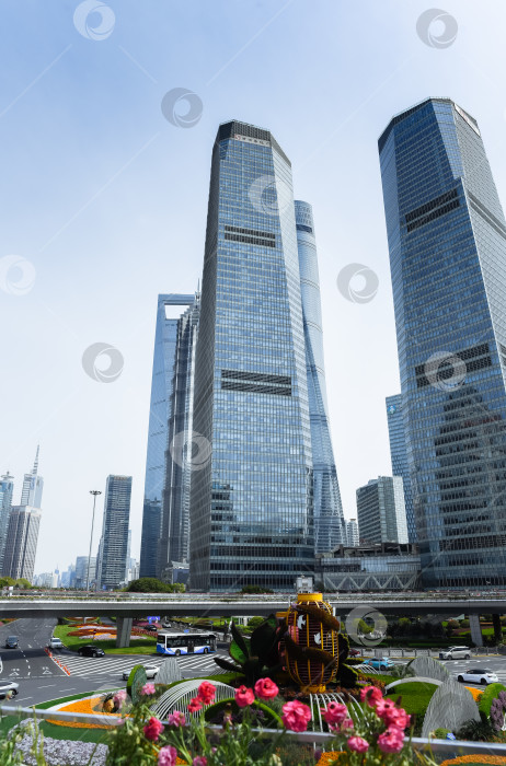 Скачать Шанхай, Китай - 1 апреля 2025 года: Современные небоскребы, включая Шанхайскую башню и Шанхайский всемирный финансовый центр, расположены в финансовом районе Пудун с оживленным городским движением. фотосток Ozero