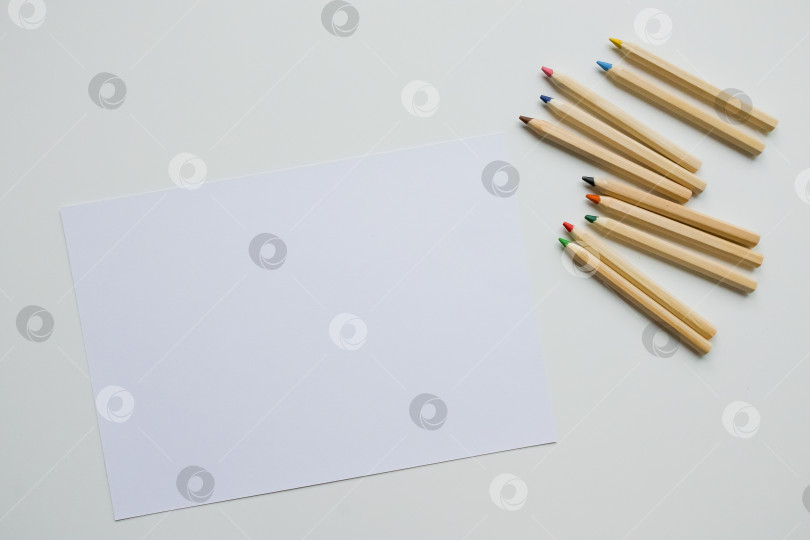 Скачать Чистый лист с разноцветными карандашами на белой поверхности фотосток Ozero