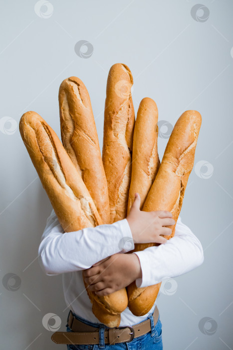 Скачать Человек, держащий в руках несколько багетов на белом фоне фотосток Ozero