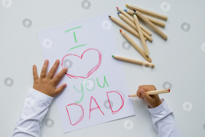 Скачать Детский почерк "Я люблю тебя, папа", рисующий разноцветными карандашами. День отца фотосток Ozero