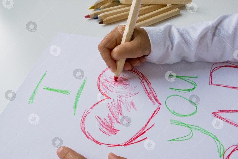 Скачать Ребенок рисует сердце цветными карандашами на белой бумаге. День отца фотосток Ozero