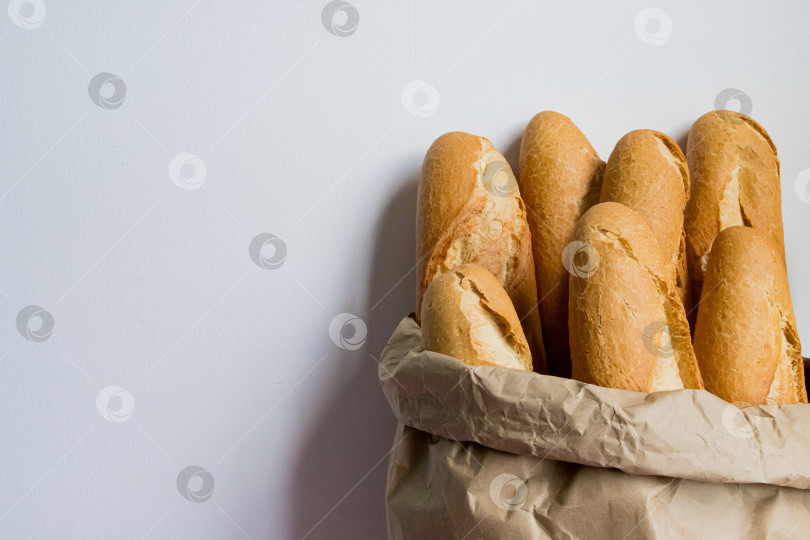 Скачать Свежеиспеченные багеты в бумажном пакете на белом фоне фотосток Ozero