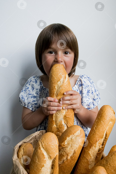 Скачать Молодая кавказская девушка наслаждается свежеиспеченными багетами фотосток Ozero