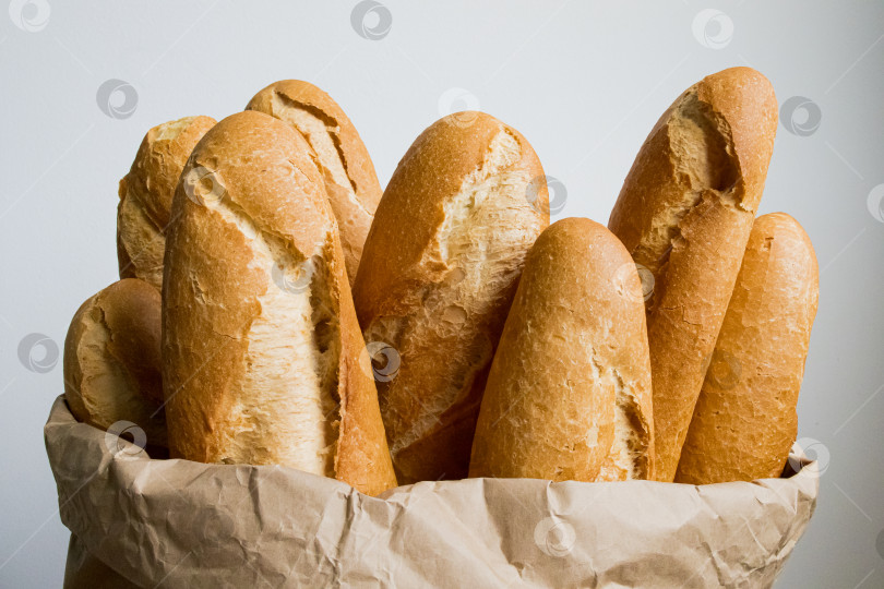 Скачать Свежеиспеченные багеты высыпаются из коричневого бумажного пакета фотосток Ozero