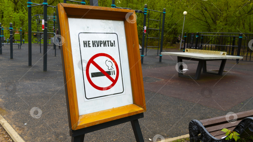 Скачать табличка "не курить" на фоне спортивной площадки фотосток Ozero