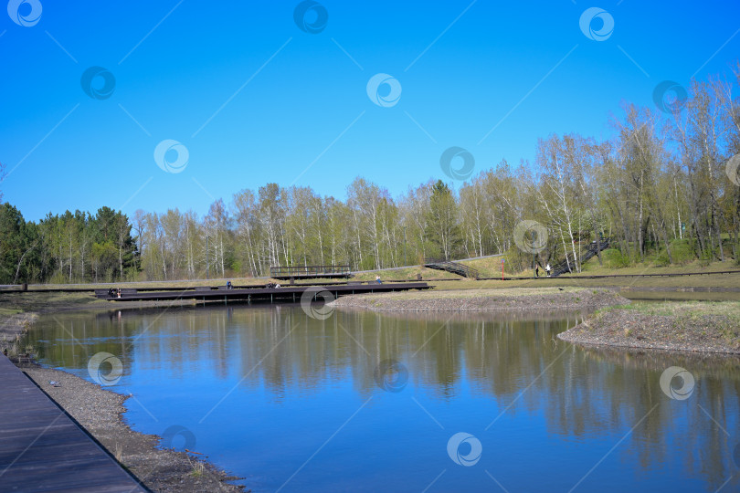 Скачать Красноярский городской парк с голубым озером в солнечный весенний день. фотосток Ozero