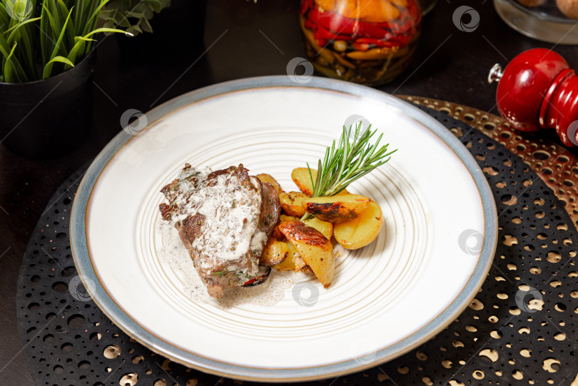 Скачать Говяжий стейк на гриле с картофелем и сливочным соусом. фотосток Ozero